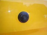 a close up of a button on the side of a yellow car