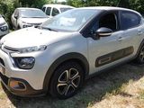 une petite voiture argentée garée dans l'herbe, près d'autres voitures