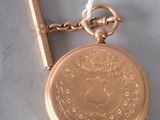 a gold pocket watch with a key on a chain