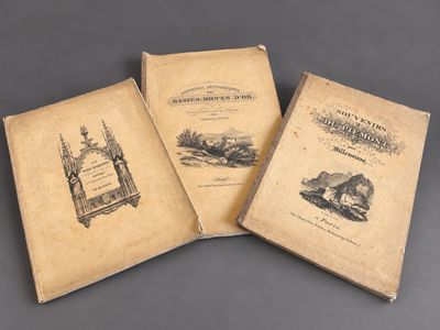three old books sitting on top of a table next to each other