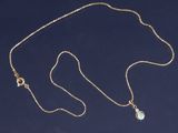 une photo d'un collier en or orné d'une pierre verte