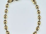 a gold chain bracelet with a clasp on a white background