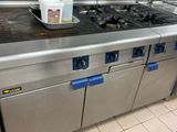 a large stainless steel stove top in a commercial kitchen
