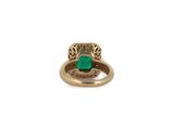 a close up of a gold ring with a green stone