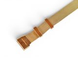 the watch strap is tan and has a brown buckle