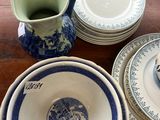 beaucoup d'assiettes et de bols bleus et blancs sur la table