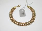 gros plan d'un bracelet en chaîne en or avec une étiquette de prix