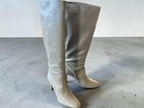 a close up of a pair of white boots on a concrete floor