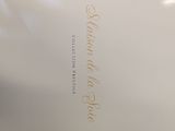 a picture of a white plate with gold writing on it