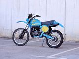 a blue and yellow dirt bike parked in a parking lot