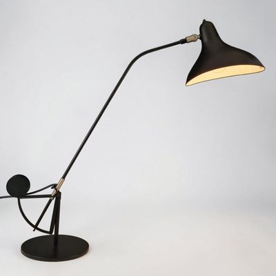 une lampe de bureau noire surmontée d'une ampoule blanche