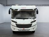 a white bus that is parked in a room