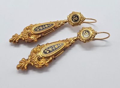 deux paires de boucles d'oreilles en or et émail noir sur un fond blanc