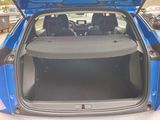 the back of a blue car with its trunk open in a parking lot