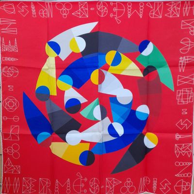 une image représentant une écharpe rouge ornée d'un motif circulaire