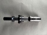 a close up of a rifle scope on a metal surface
