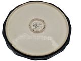 a close up of a white and black bowl on a white surface