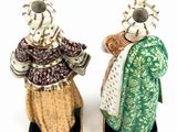 pair of ceramic figurines of two people dressed in traditional clothing
