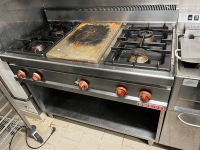 une plaque de cuisson sale dans une cuisine, sur laquelle se trouve une plaque de cuisson