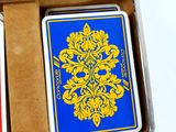 two playing cards in a metal case on a table