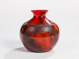 a red vase that has a bird design on it