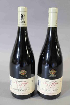 deux bouteilles de vin posées sur une table l'une à côté de l'autre