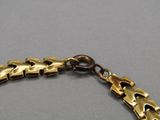 un gros plan sur un bracelet en or muni d'une chaîne