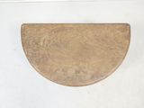 a small wooden plate on a white wall next to a window