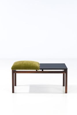 un petit banc sur lequel est posé un coussin vert