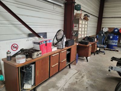 un garage où le sol est encombré d'objets divers et de bric-à-brac