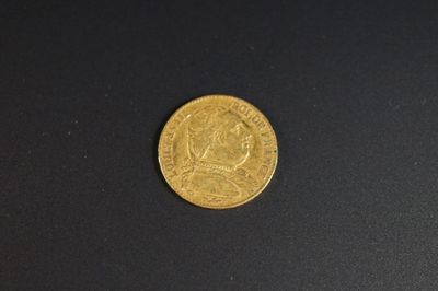 gros plan d'une pièce d'or sur une surface noire