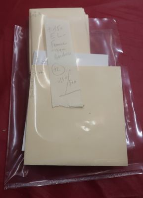 two envelopes and a piece of paper on a red cloth
