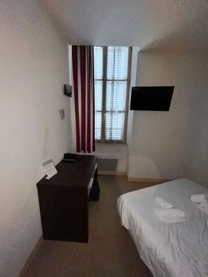 un petit lit dans une petite chambre équipée d'une télévision à écran plat