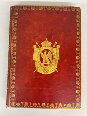 un vieux livre rouge orné d'un emblème doré