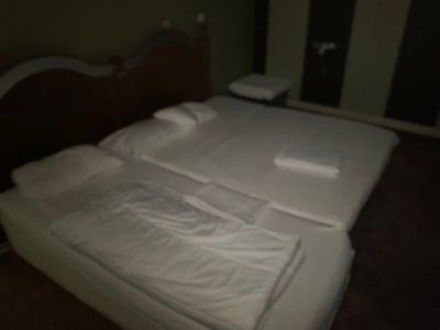 un lit recouvert de draps blancs dans une pièce sombre