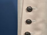 a close up of a white jacket with buttons on it