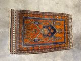an orange and blue rug laying on top of a cement floor