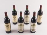 six bottles of wine are lined up on a white surface