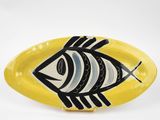 une assiette jaune sur laquelle est représenté un poisson en noir et blanc
