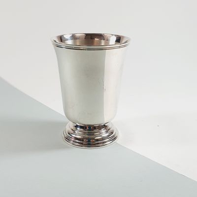 a silver cup sitting on top of a white table