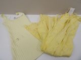 deux pulls jaunes et une robe jaune posés sur une table blanche