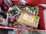 a red box filled with assorted items on the street