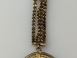 une image représentant un porte-clés orné d'une pièce d'or