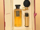 une boîte ouverte contenant un flacon de parfum et un micro