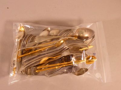 a lot of silver and gold spoons and spoons in a bag
