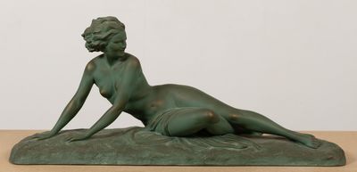 statue représentant une femme allongée sur un rocher posé sur une table