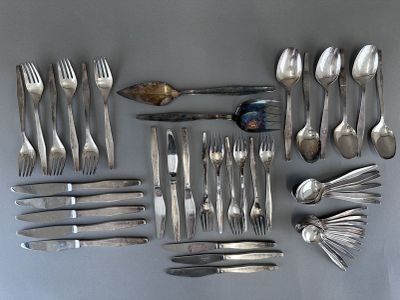 a lot of silver spoons and forks laid out on a table