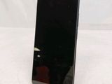 the back of a black cell phone sitting on top of a white table