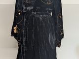 an image of a black dress with gold flowers on a mannequin