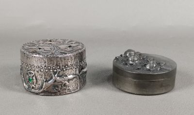 deux petites boîtes en argent posées l'une à côté de l'autre sur une table